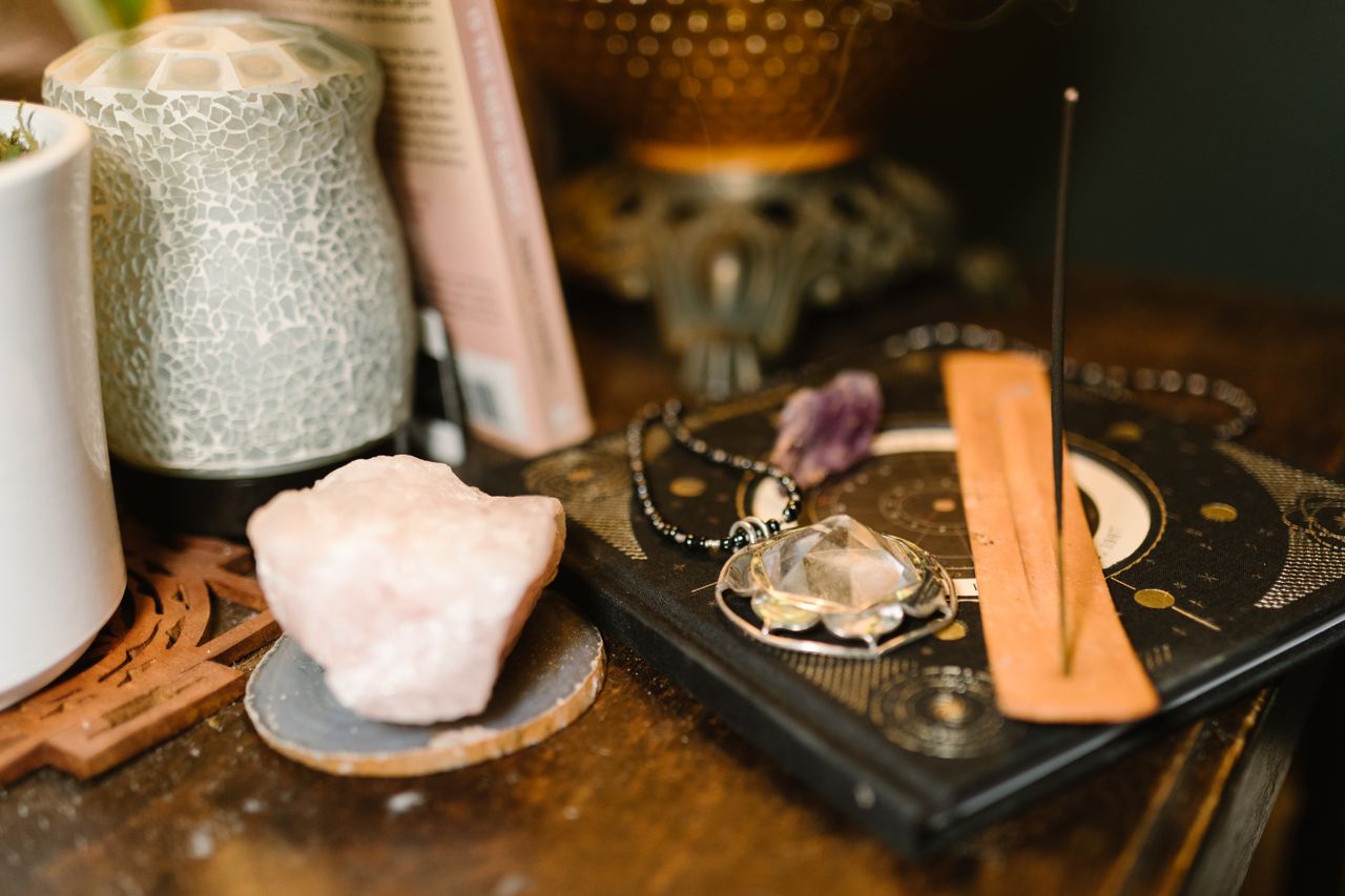 Services Warm-toned composition featuring incense, rose quartz, and mystical elements on a wooden surface.