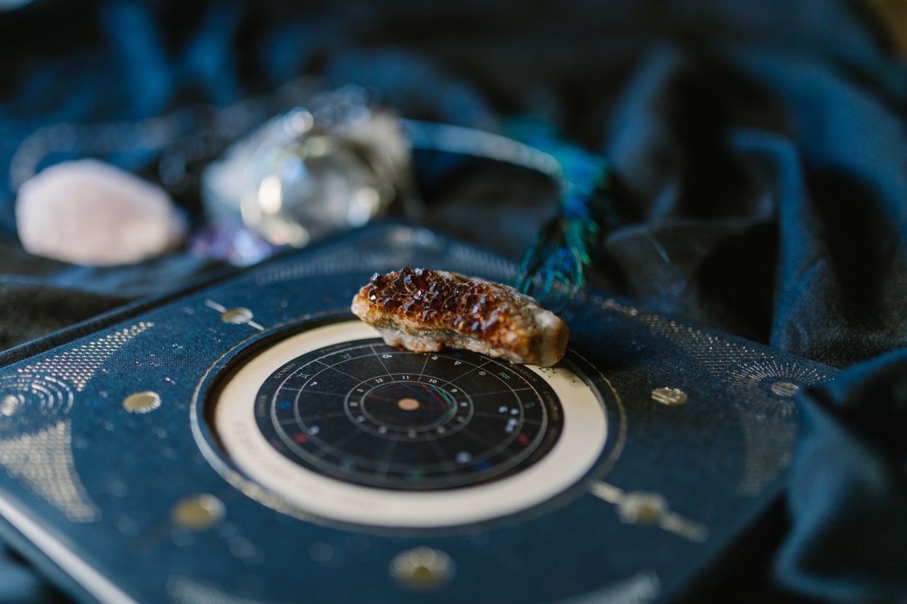 Services Close-up of crystals on an astrology chart atop dark fabric for a mystical vibe.