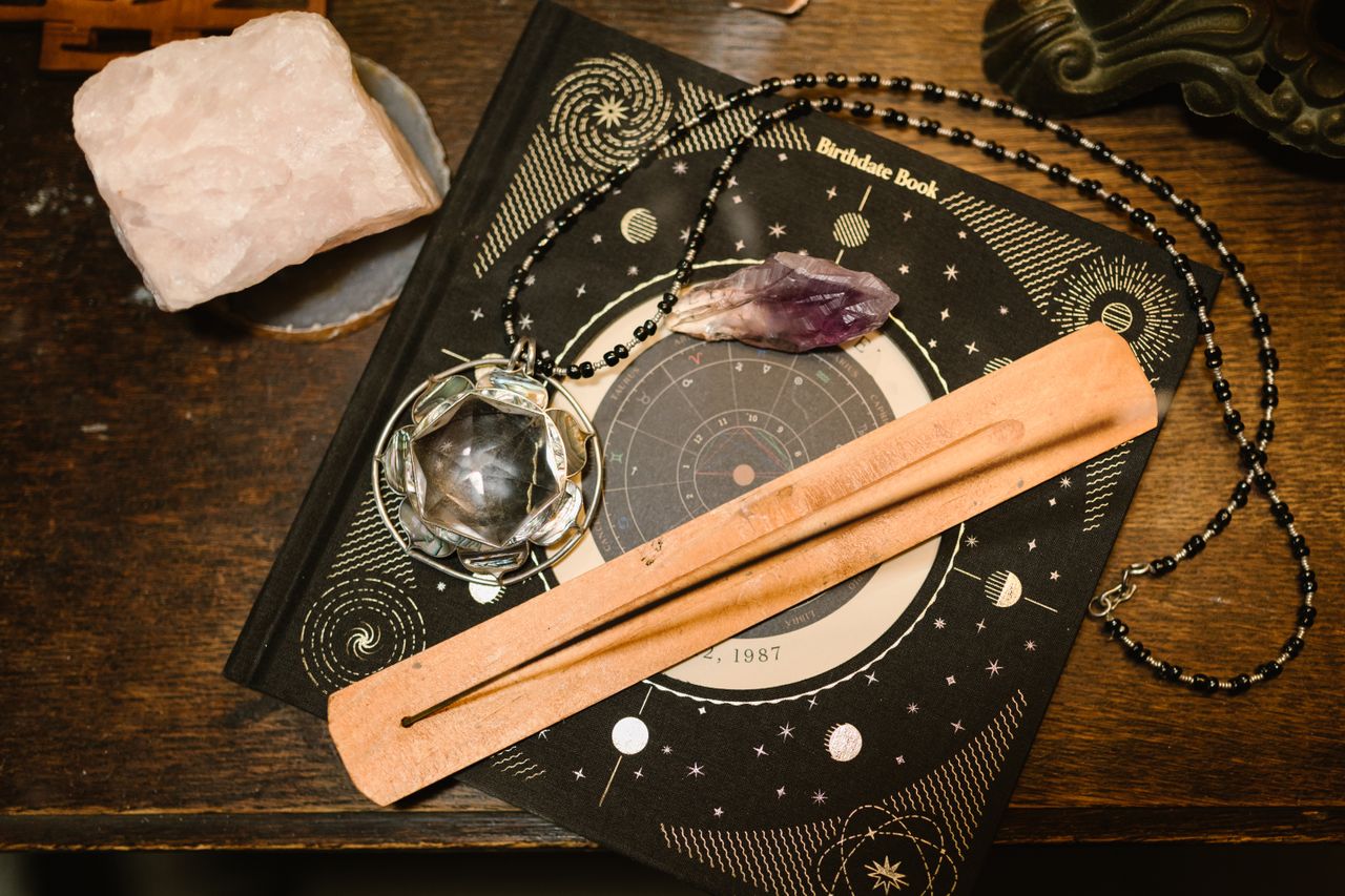 Services Top view of an astrology book, crystals, and incense holder for mystical ambiance.